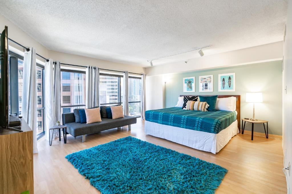 a bedroom with a bed and a couch and a tv at Spacious Downtown Executive Retreat - Free Parking in Honolulu