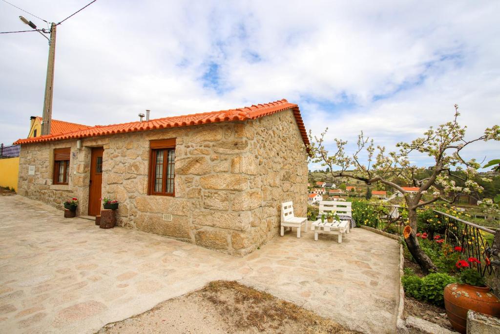 Casa de piedra pequeña con patio con 2 sillas en 2 bedrooms house with city view shared pool and enclosed garden at Sortelha, en Sortelha