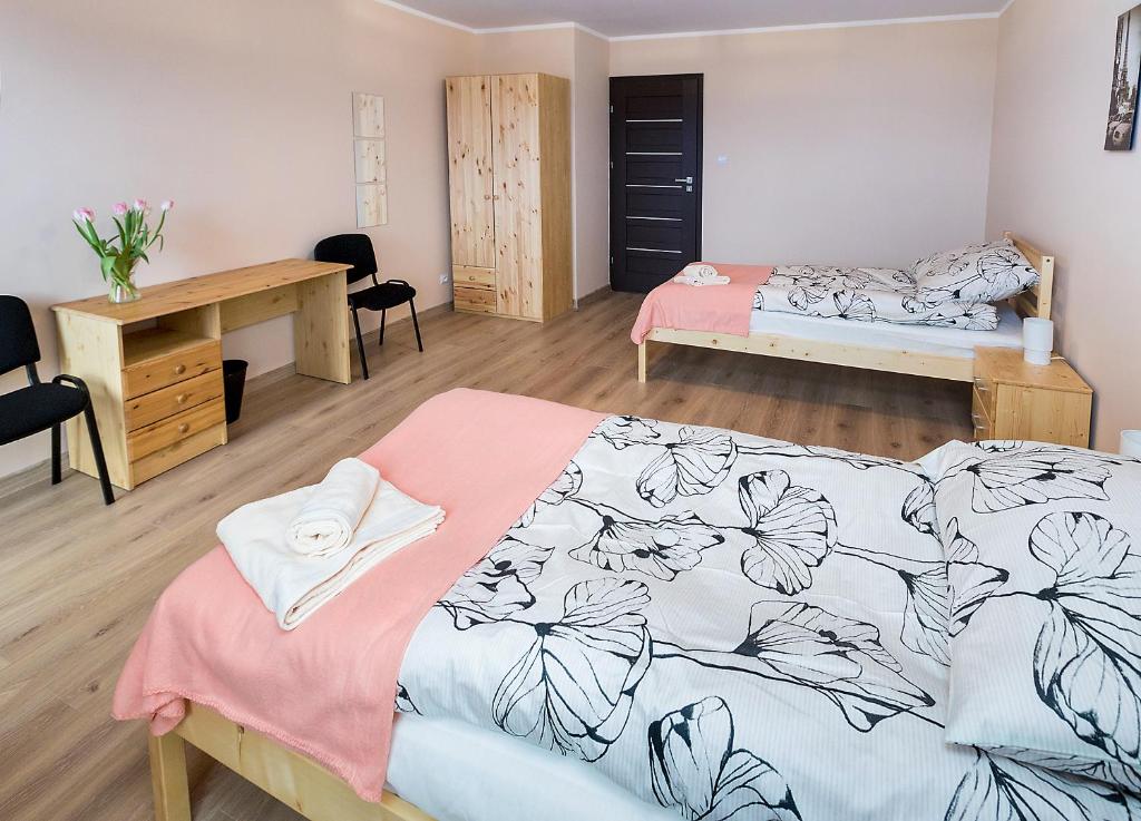 a bedroom with a bed and a desk and a desk at Moody Hostel in Mława