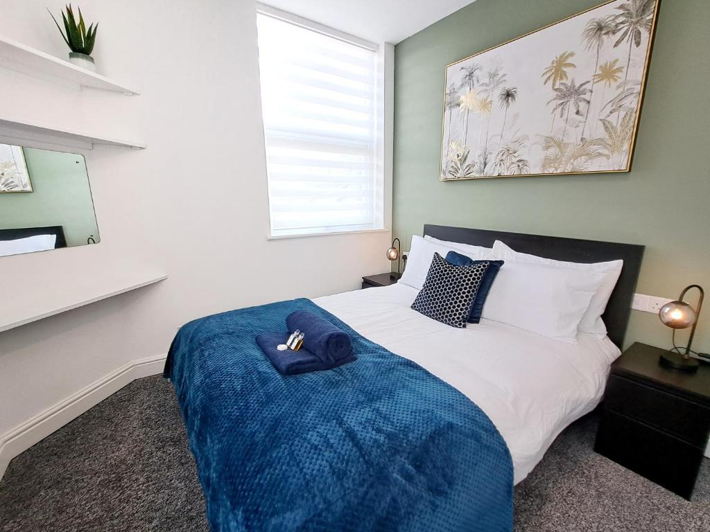 a bedroom with a bed with a blue blanket at Bright 3 Bed Apartment With Terrace, Free Parking! in Watford