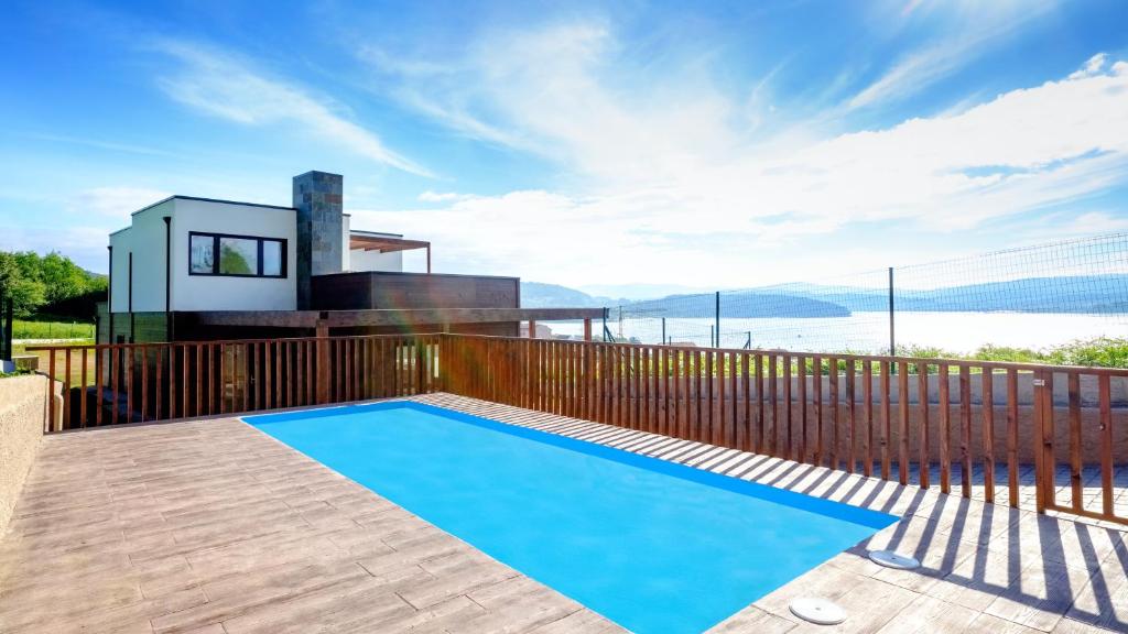 a swimming pool on the deck of a house at 3 bedrooms house with sea view private pool and enclosed garden at Outes 3 km away from the beach in Outes