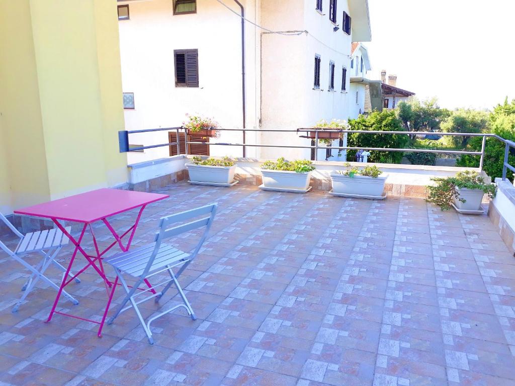 Canosa Sannitaにある2 bedrooms appartement with sea view enclosed garden and wifi at Canosa Sannitaのパティオ(ピンクのテーブル、椅子付)