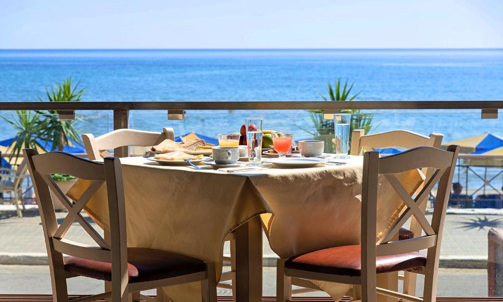 a table with food and a view of the ocean at Sunlight Beach Hotel in Georgioupolis