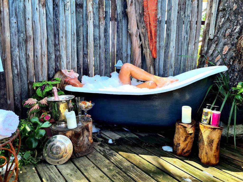 um homem deitado numa banheira num jardim em Fairfield Cottages em Ceres