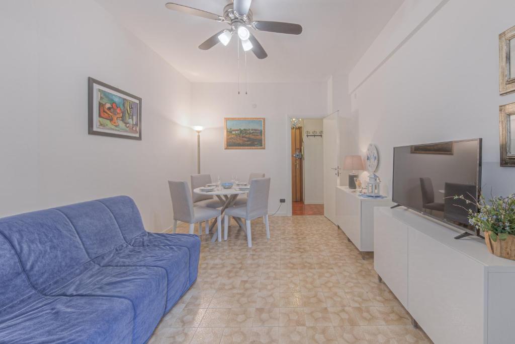 a living room with a blue couch and a dining room at RAPALLO APARTMENT Comodo e in Ottima Posizione in Rapallo