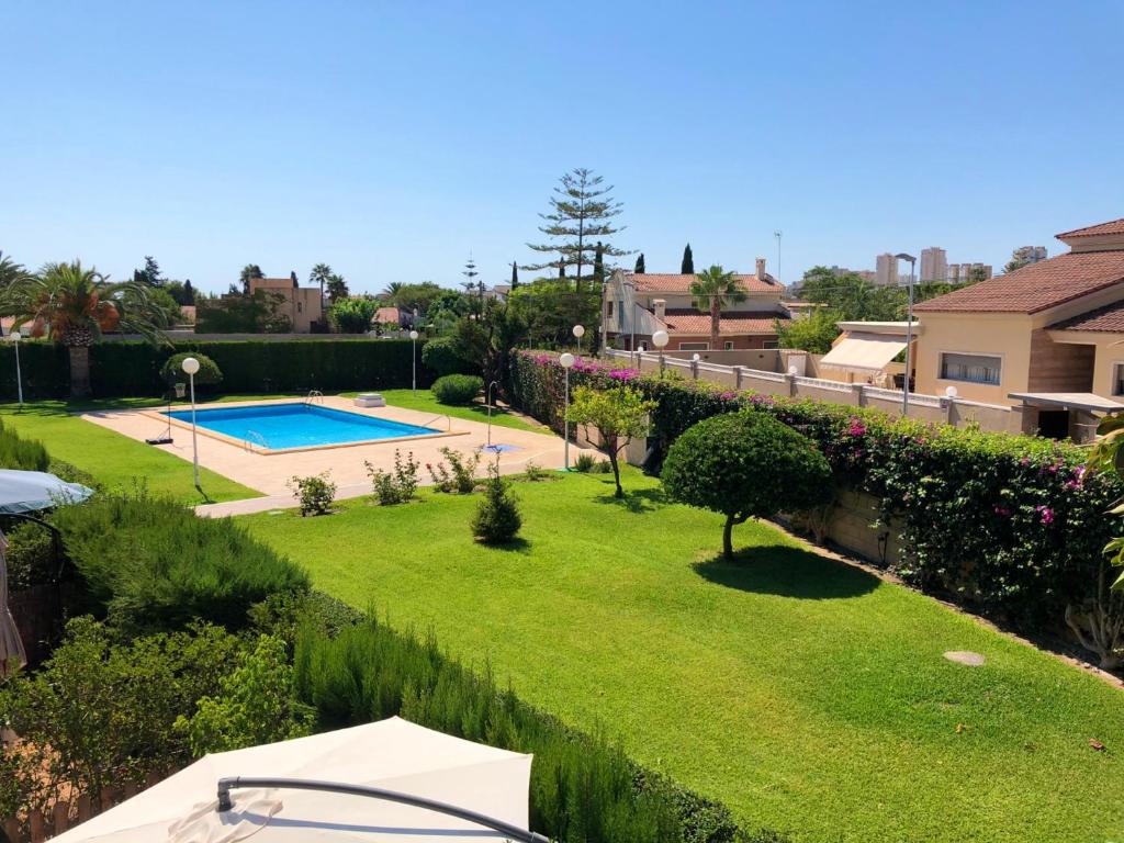 エル・カンページョにある3 bedrooms house with shared pool furnished terrace and wifi at Sant Joan d'Alacant 1 km away from the beachのスイミングプール付きの庭の景色を望めます。