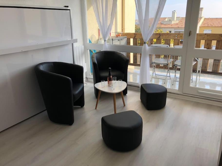 une chambre avec trois chaises, une table et une fenêtre dans l'établissement studio tout équipé place de parking centre port, au Cap d'Agde