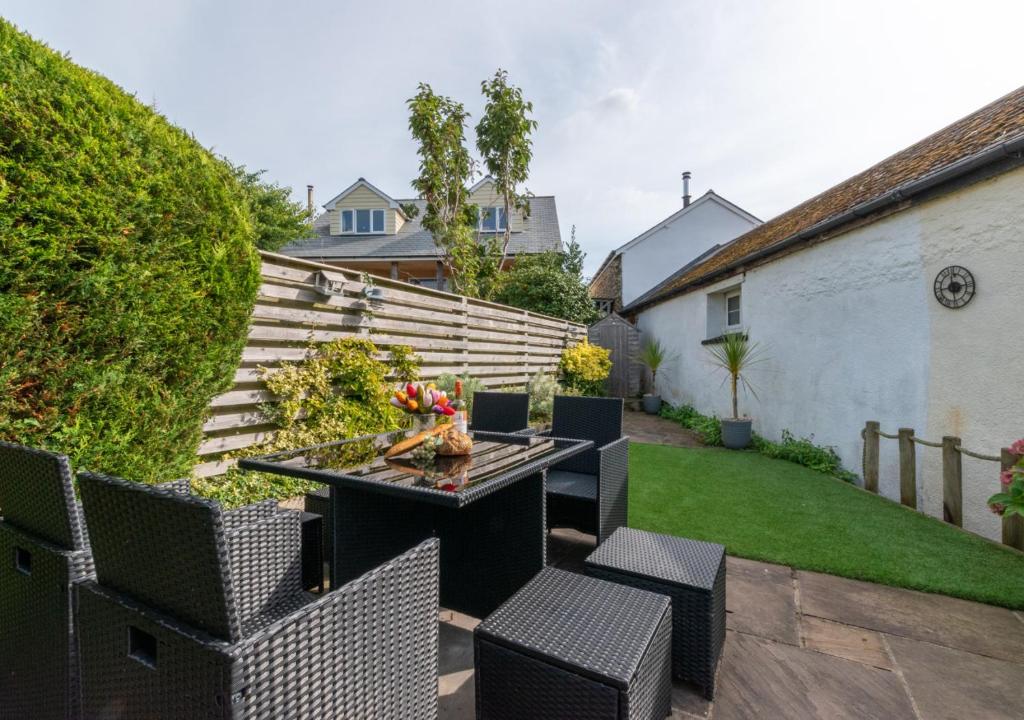 a patio with a table and chairs in a yard at Willow Cottage in Braunton