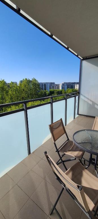 a patio with a glass table and chairs on a balcony at WellSituated 1 Bedroom Condo in Warsaw freeparking in Warsaw