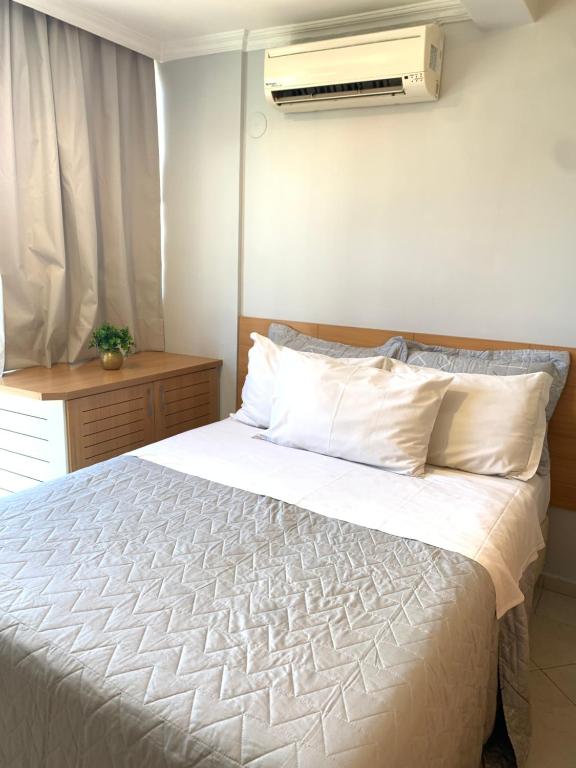 a bedroom with a bed with a white comforter at Apart Hotel Centro de Brasília (Garvey Park Hotel) in Brasilia
