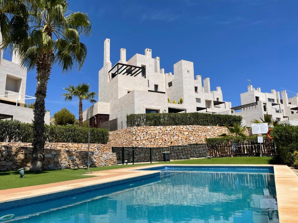 ein Gebäude mit einem Swimmingpool vor einem Gebäude in der Unterkunft Corvera Hills, Corvera Golf and country club in Corvera