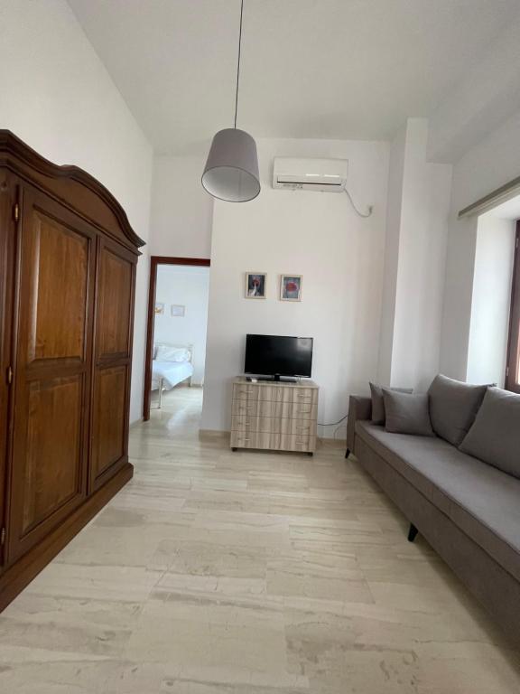 a living room with a couch and a tv at Aphaias Apartments in Aegina Town