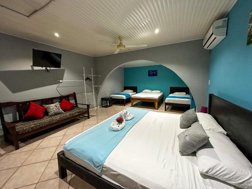 ein Schlafzimmer mit einem großen Bett und einem Sofa in der Unterkunft Hospedaje Colibri in Manuel Antonio