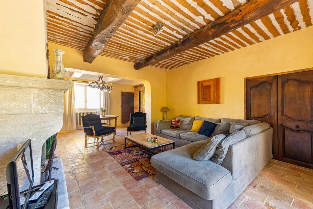 a living room with a couch and a tv at Villa de 6 chambres avec piscine privee jardin clos et wifi a Saignon in Saignon
