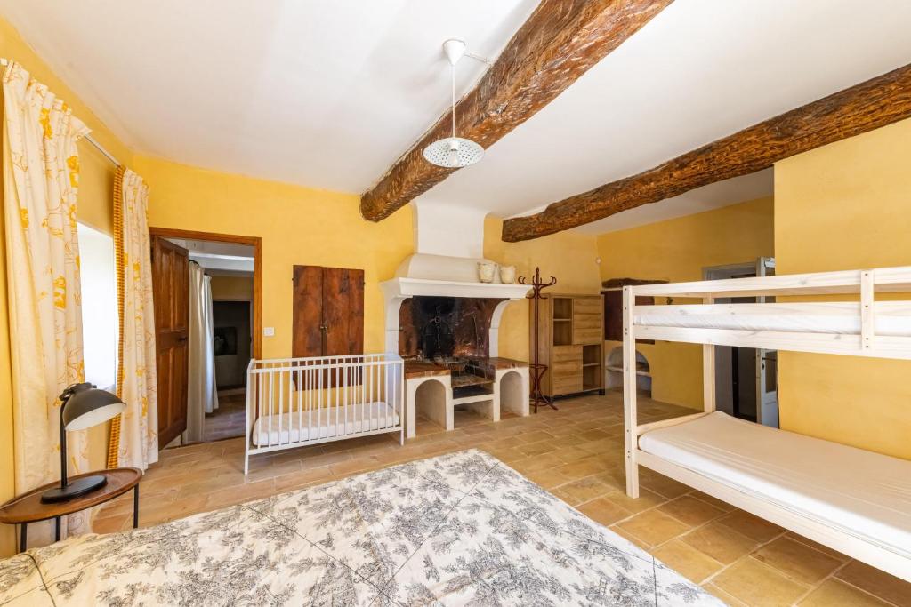 a bedroom with a bunk bed and a fireplace at Villa de 6 chambres avec piscine privee jardin clos et wifi a Saignon in Saignon