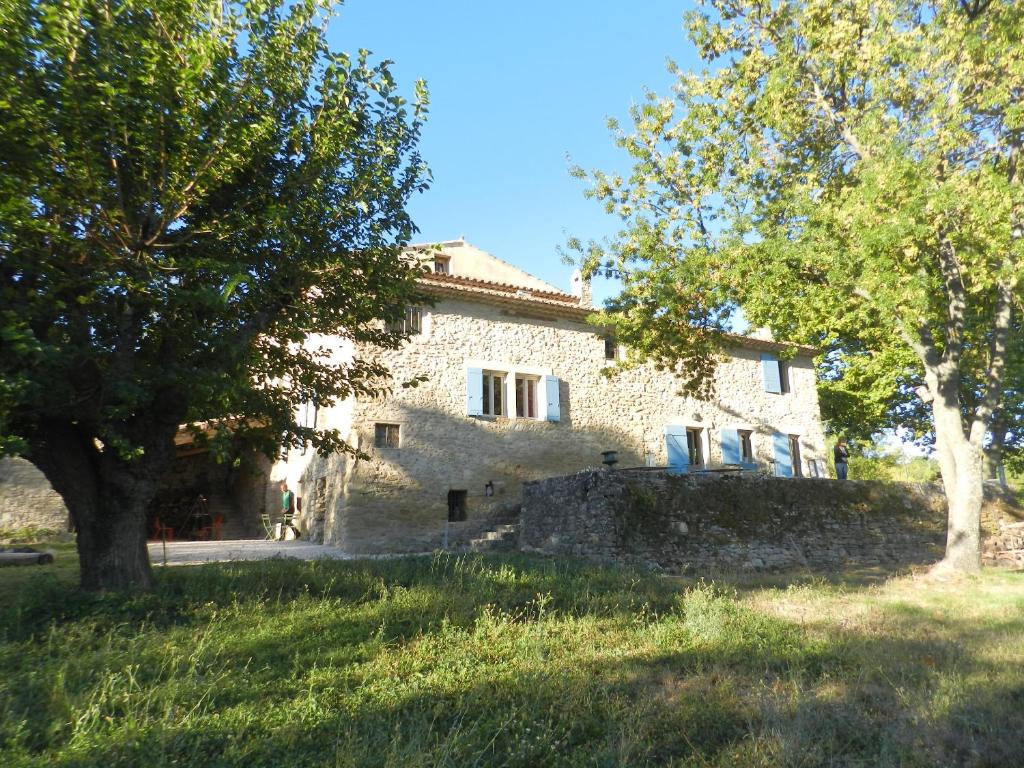 an old stone house with trees in front of it at Villa de 6 chambres avec piscine privee jardin clos et wifi a Saignon in Saignon