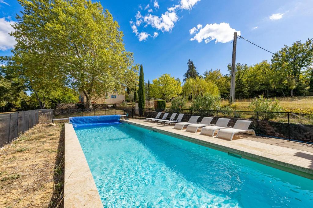 a swimming pool with lounge chairs in a backyard at Villa de 6 chambres avec piscine privee jardin clos et wifi a Saignon in Saignon
