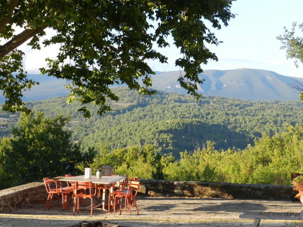 a table and chairs with a view of mountains at Villa de 6 chambres avec piscine privee jardin clos et wifi a Saignon in Saignon