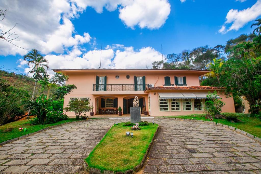 a house with a stone driveway in front of it at Hotel Solar Fazenda Do Cedro in Itaipava