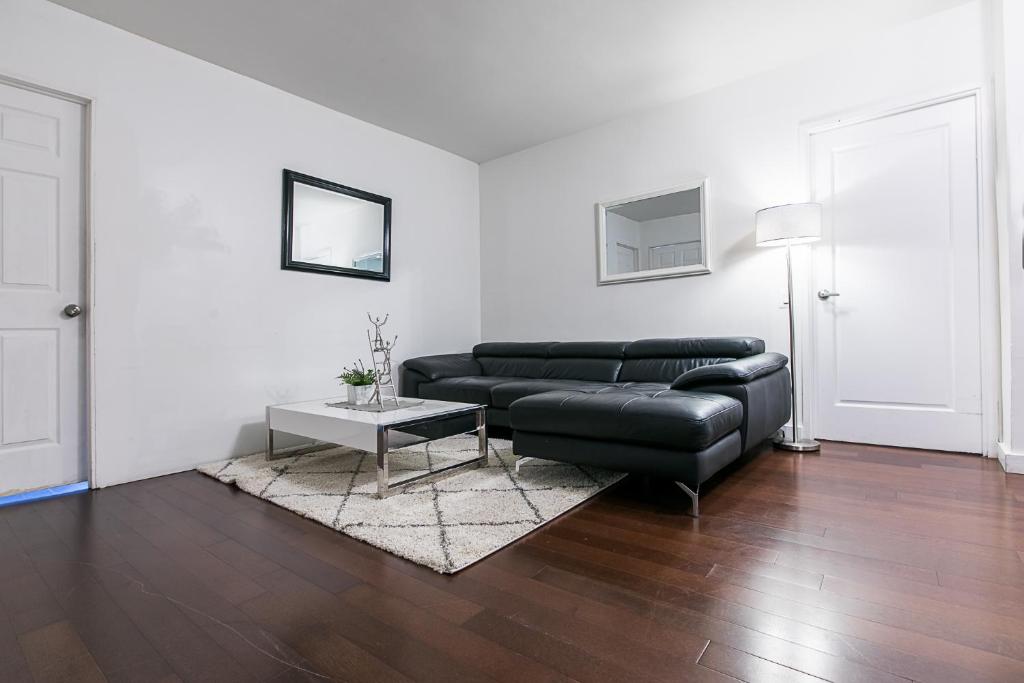 ein Wohnzimmer mit einem schwarzen Ledersofa und einem Tisch in der Unterkunft 3 BR with Splendid River views in New York