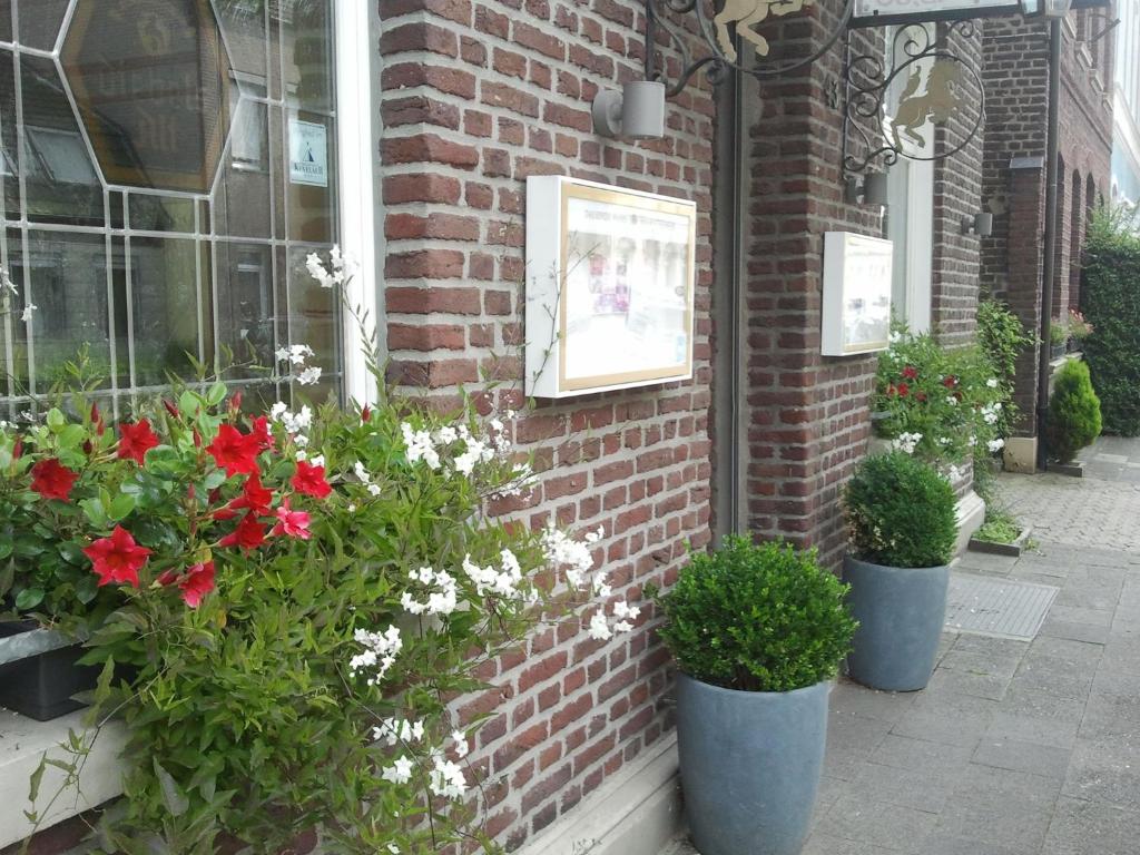 um grupo de flores em vasos do lado de um edifício em Gelder Dyck em Kevelaer