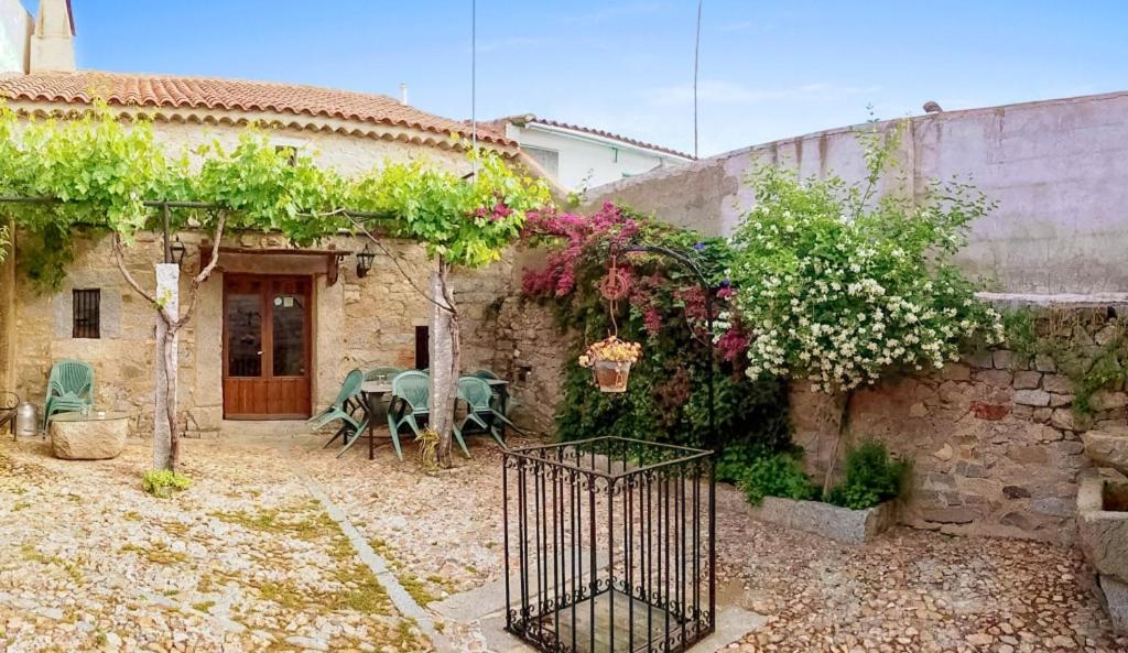 a stone house with a table and chairs in a yard at Charming House in Añora with Garden in Anora