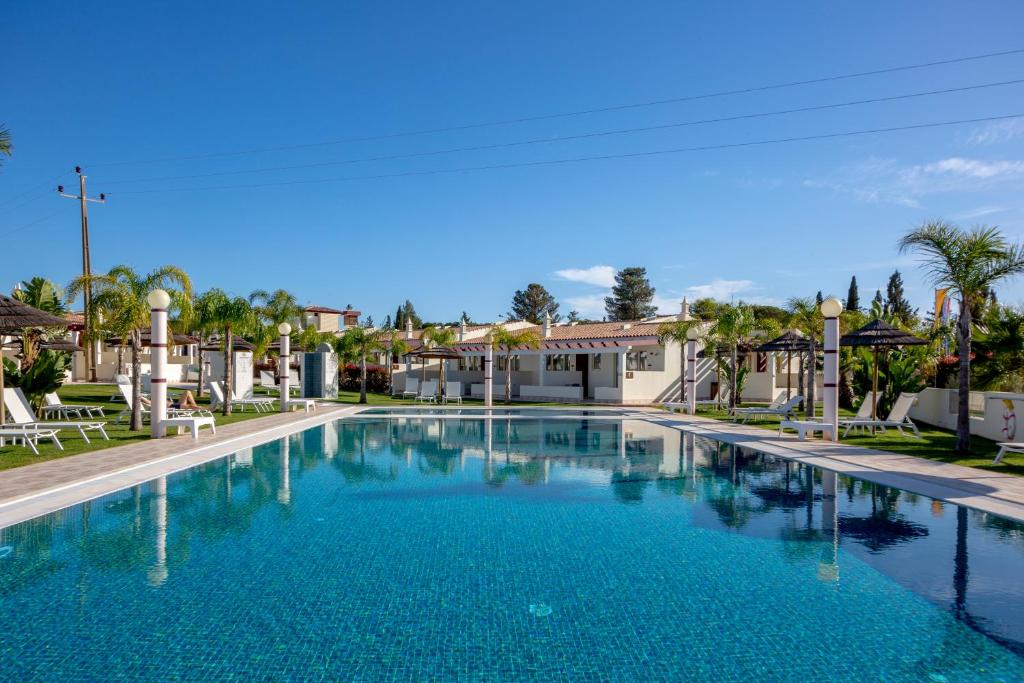 a large blue swimming pool in a resort at Hotel Rural Brícia Du Mar in Ferragudo