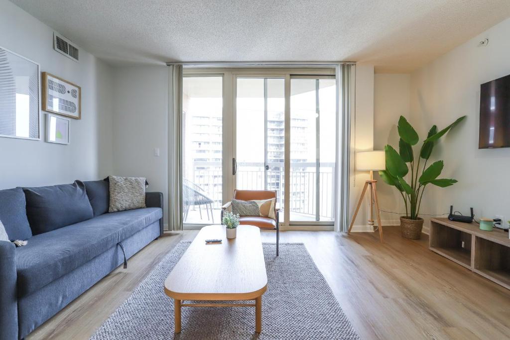 アーリントンにあるAmazing 2 Bedrooms Condo at Ballston with gymのリビングルーム(青いソファ、テーブル付)