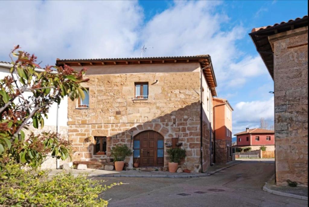 una antigua casa de piedra con una puerta grande en Spacious House in Llano de Bureba with Fireplace & Mountain View, en Llano de Bureba