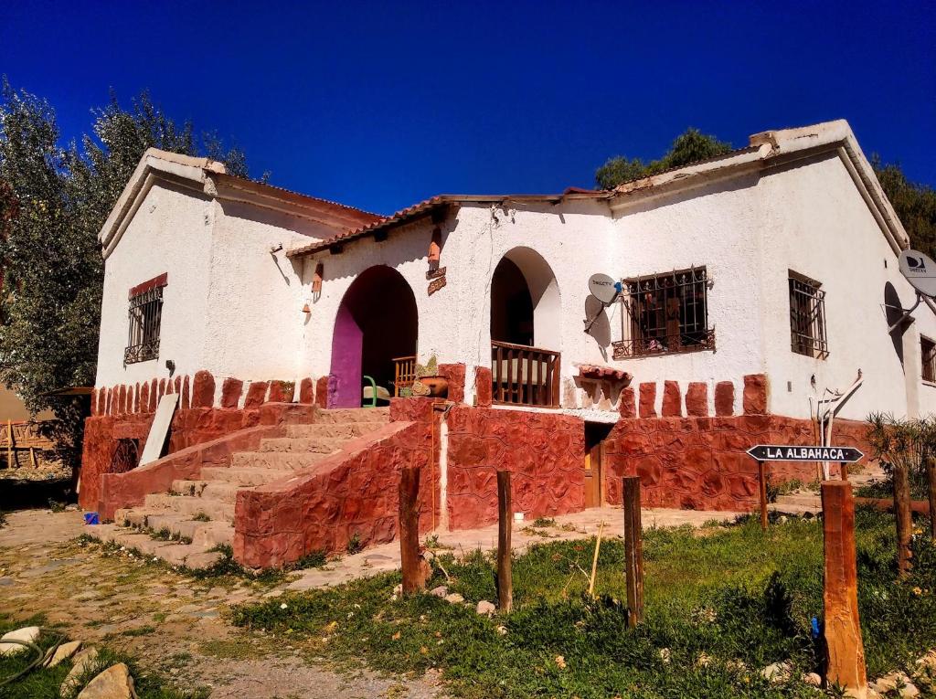 an old white house with a red brick at Familia Albahaca in Tilcara