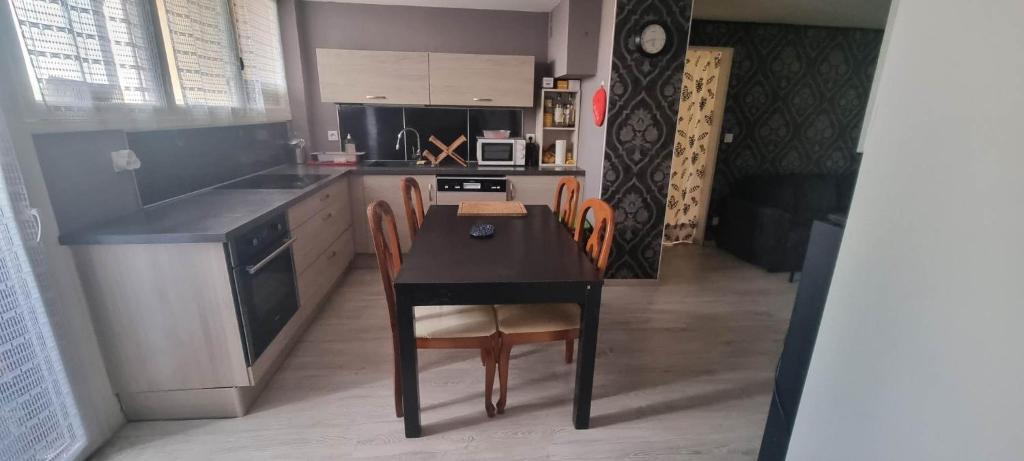 une cuisine avec une table noire et des chaises dans l'établissement L'indéniable, à Sète