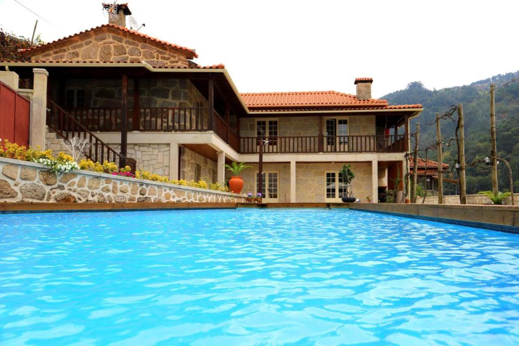 uma grande piscina em frente a uma casa em 3 bedrooms villa with private pool enclosed garden and wifi at Terras de Bouro em Terras de Bouro