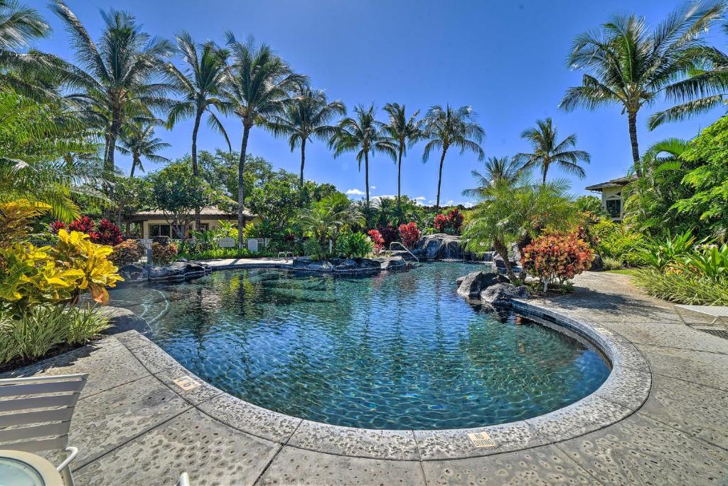 a swimming pool in a resort with palm trees at Luxe Maunalani Resort Condo with Pool and Beach Access in Waikoloa