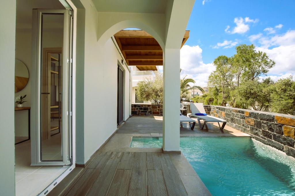a house with a swimming pool and a patio at Malena Hotel & Suites - Adults Only by Omilos Hotels in Amoudara Herakliou