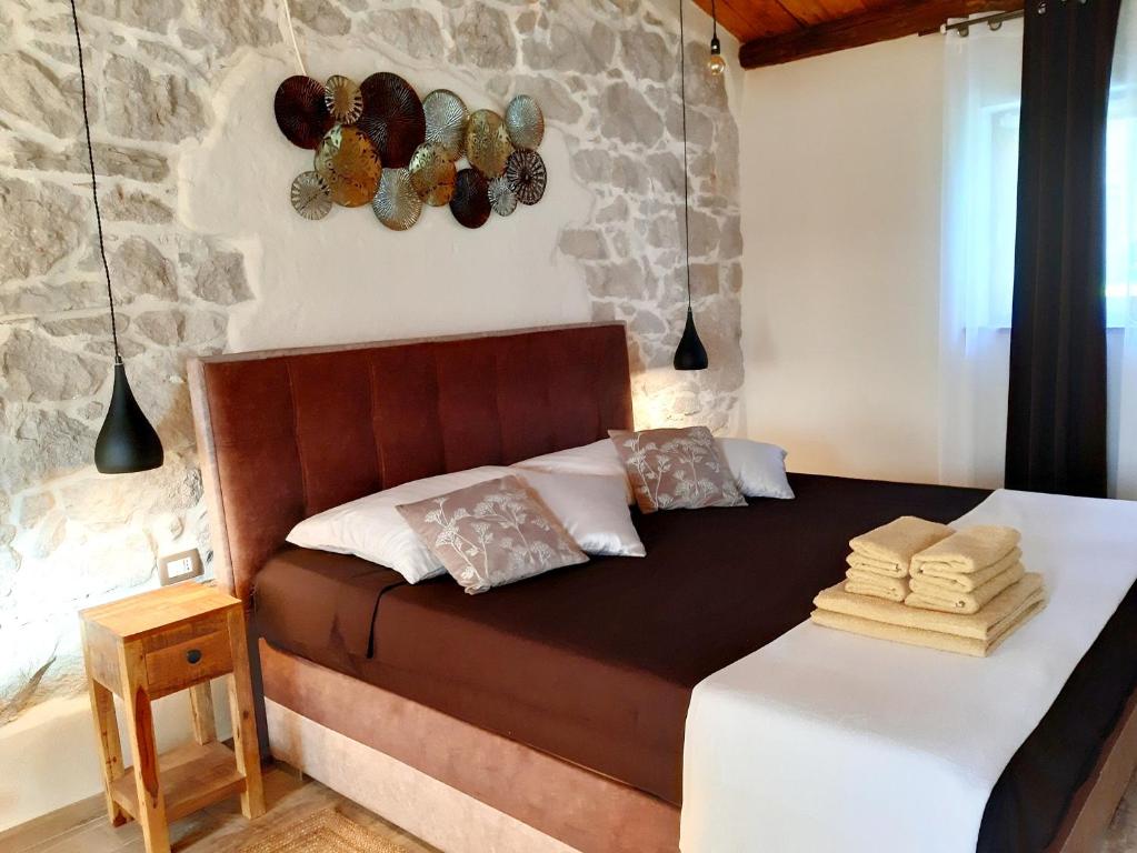 1 dormitorio con 1 cama en una pared de piedra en 3 bedrooms villa with private pool enclosed garden and wifi at Ripenda Verbanci 5 km away from the beach, en Plomin