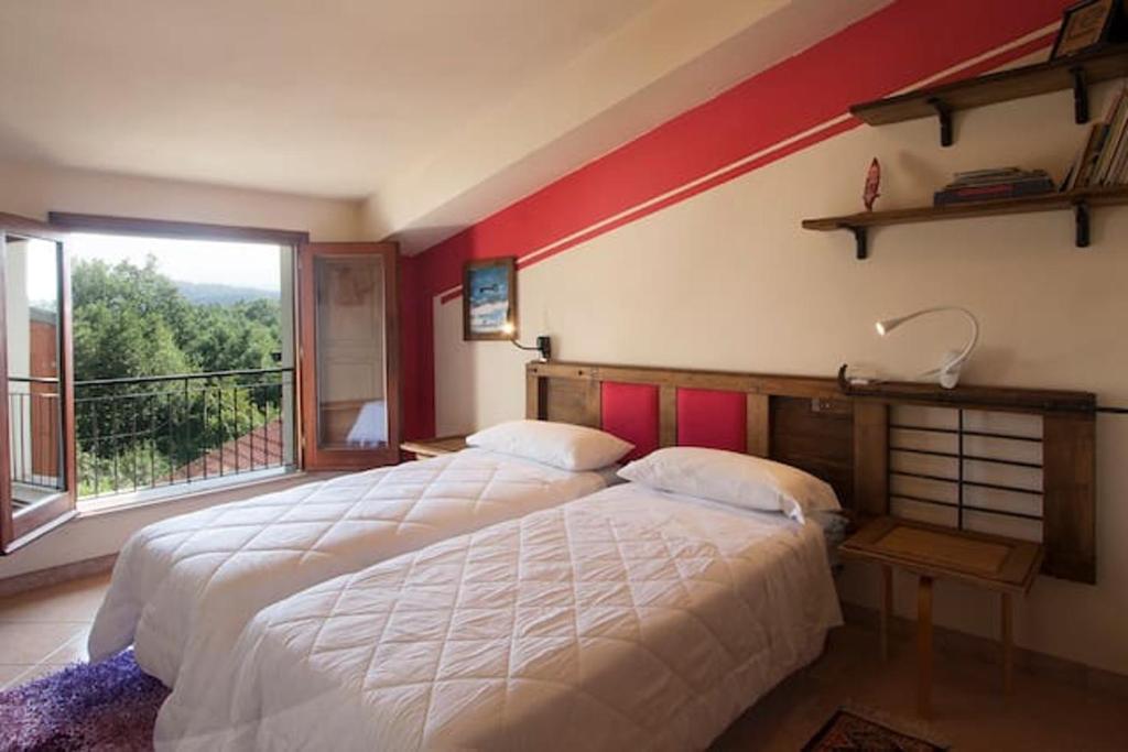 1 dormitorio con cama grande y ventana grande en 2 bedrooms house with jacuzzi enclosed garden and wifi at Decollatura, en Decollatura