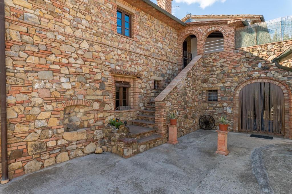 un edificio de piedra con escalera y puerta en Casa Vecchia Rooms and Parking, en Gambassi Terme