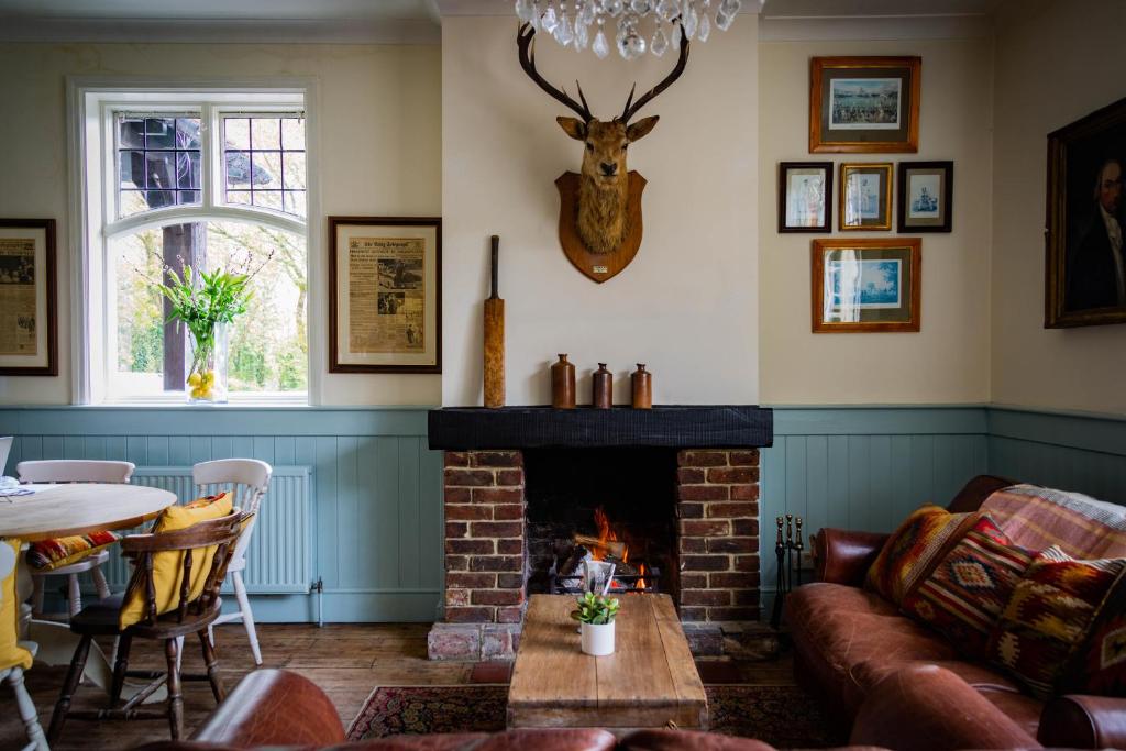 sala de estar con sofá y chimenea en The Cricketers Inn en Petersfield