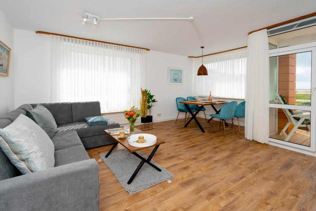 - un salon avec un canapé et une table dans l'établissement Meeresrauschen, à Westerland