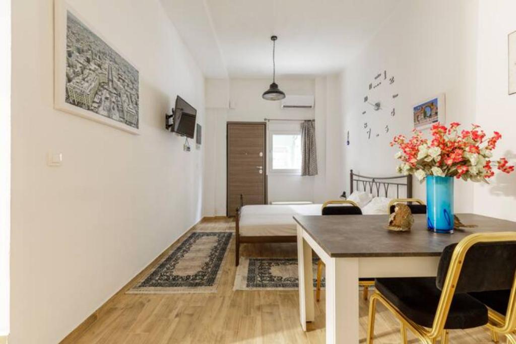 een kamer met een bed en een tafel met een vaas met bloemen bij Perfect Apartment 71B in Thessaloniki