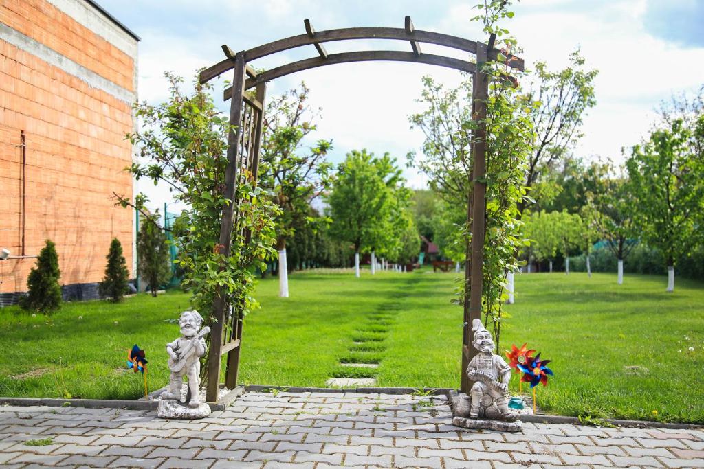 an archway with statues in a park at House Garden in Turda