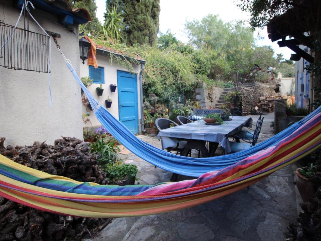 uma rede de descanso arco-íris pendurada num jardim em Maison Port-Vendres, 7 pièces, 5 personnes - FR-1-309-369 em Port-Vendres