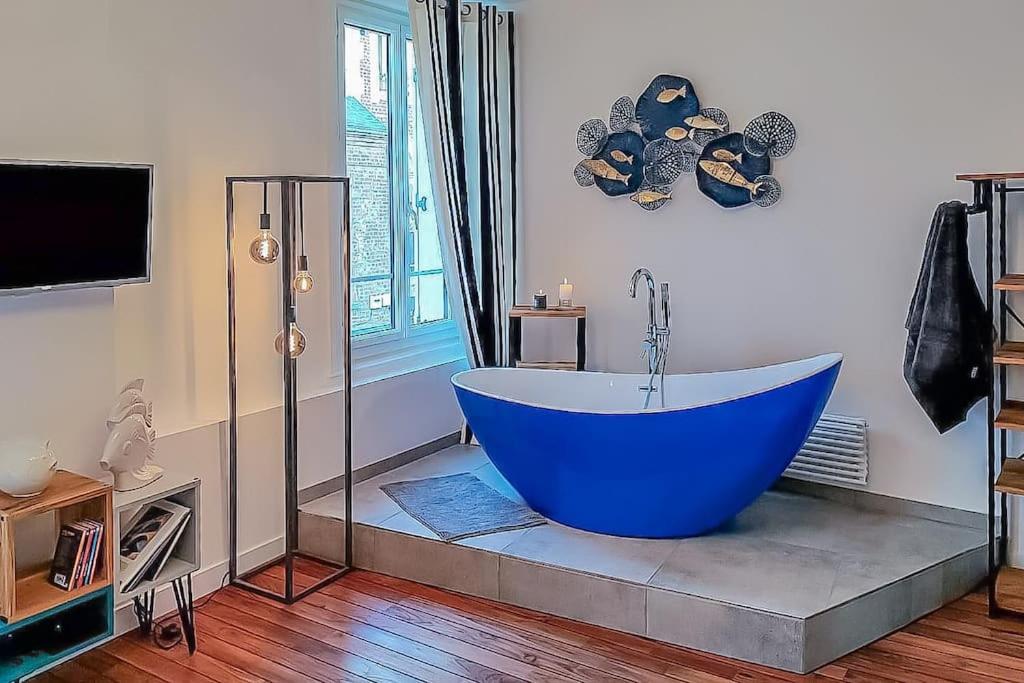 a bathroom with a large blue tub in a room at The blue suite Etretat in Étretat