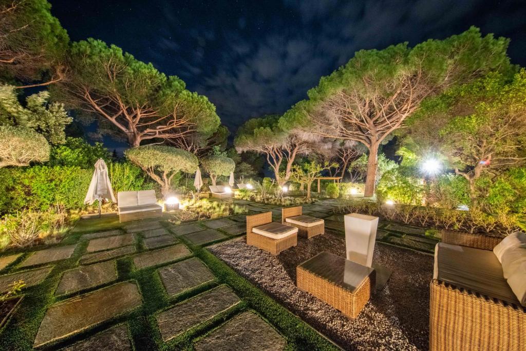 a garden at night with chairs and lights at Les Capucines Saint Tropez in Saint-Tropez