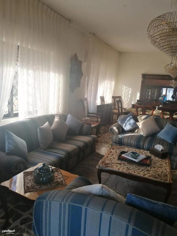 a living room with couches and tables at Duraidi in Amman