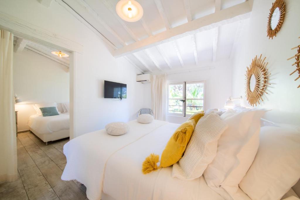a white bedroom with a bed and a couch at Les Capucines Saint Tropez in Saint-Tropez