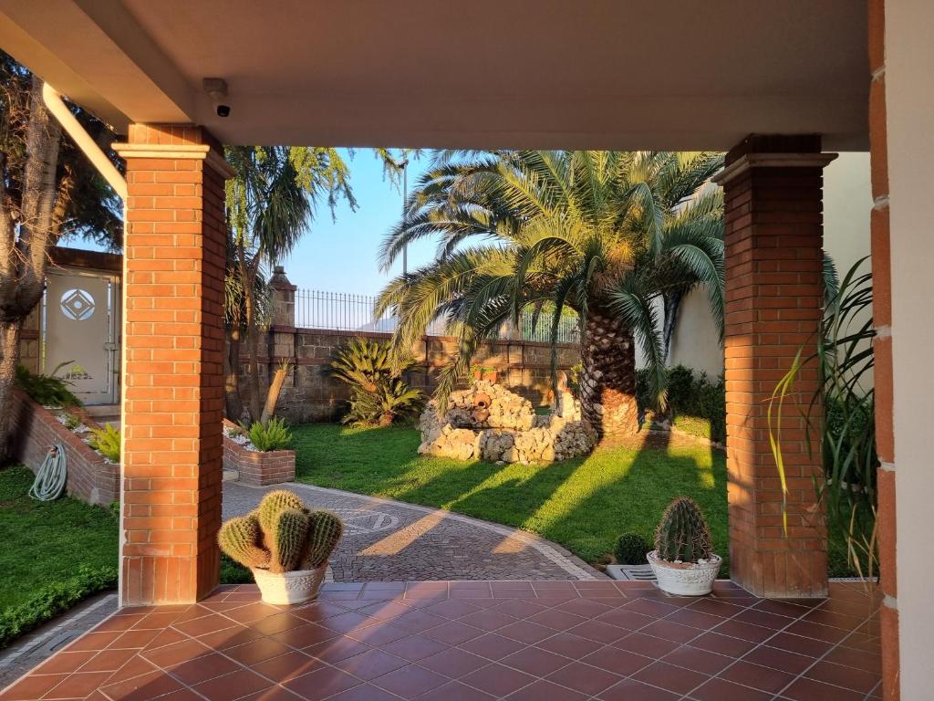 a patio with a view of a yard with palm trees at Villa Sweery in Santa Maria a Vico