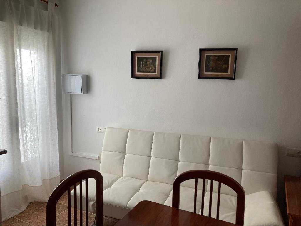 - un salon avec un canapé blanc et une table dans l'établissement La Casa de Paco el Ventero Los Bolillos, à Almócita