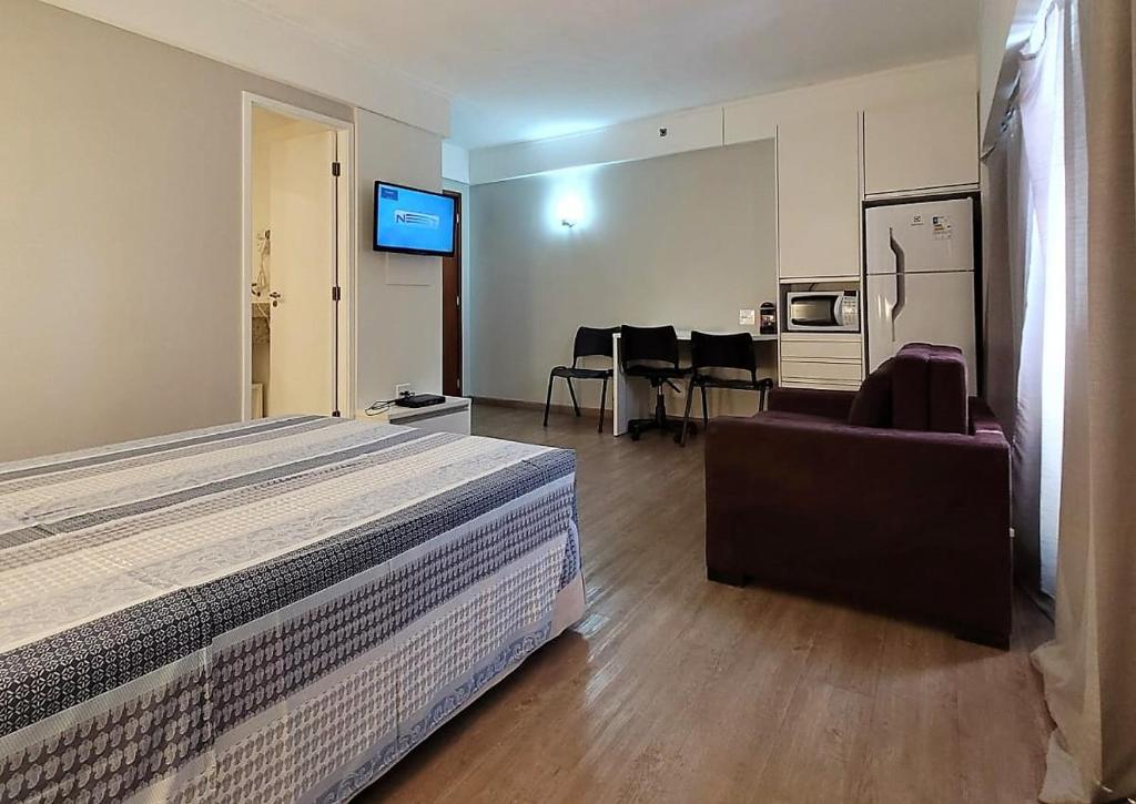 a hotel room with a bed and a dining room at Flat R Borges Lagoa Ibirapuera c/ garagem UH1005 in Sao Paulo