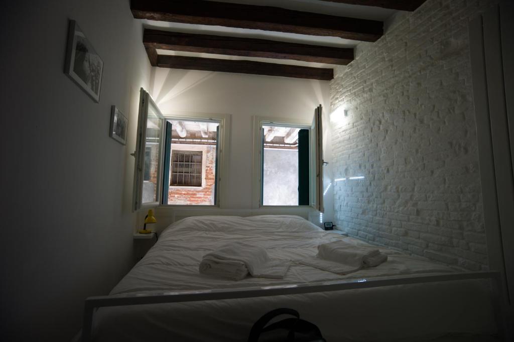 a bed in a room with a brick wall at Ca' di Paolo in Venice